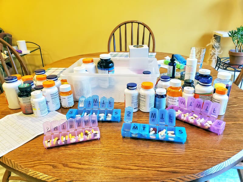 Kitchen Table Covered with Pills and Pill Boxes Editorial Stock Photo