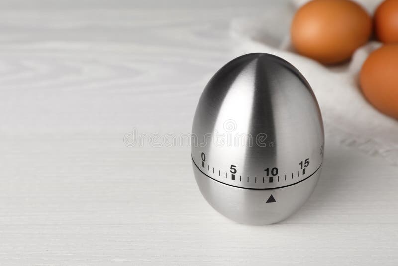 Kitchen Timer and Eggs on White Wooden Table. Space for Text Stock
