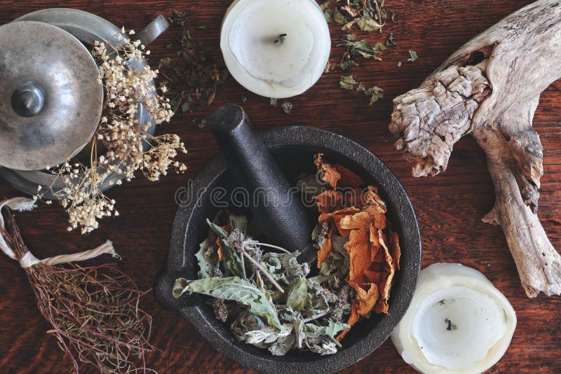 Flat lay of kitchen witchery using herbs and spices found at home. Herbal  magick in wicca and witchcraft. Glass jars filled with dried herbs and  spices, cinnamon, flowers, camomile, burning candles Stock