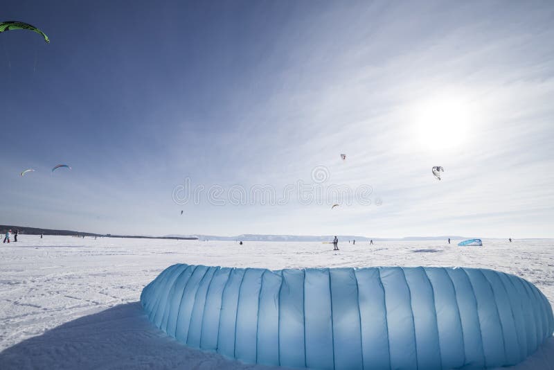 Kiteboarder met blauwe vlieger op de sneeuw stock foto's Kiteboarder met blauwe vlieger op de sneeuw stock foto's