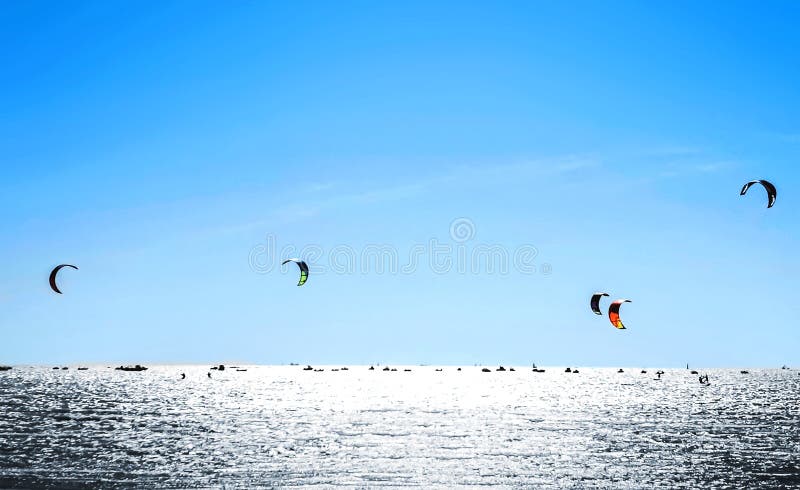 Kiteboarding Cerf-volant surfant contre un beau ciel bleu Beaucoup de silhouettes des cerfs-volants dans le ciel image libre de droits Kiteboarding Cerf-volant surfant contre un beau ciel bleu Beaucoup de silhouettes des cerfs-volants dans le ciel image libre de droits