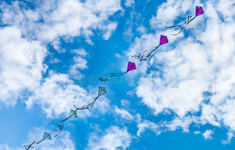 Kites flying in dramatic blue cloudy sky