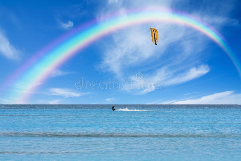 Kitesurfista en acción sobre el cancelar azul Agua arcoíris.