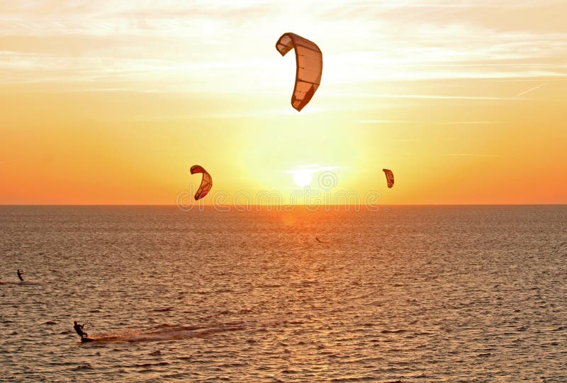 Kitesurfers bij zonsondergang