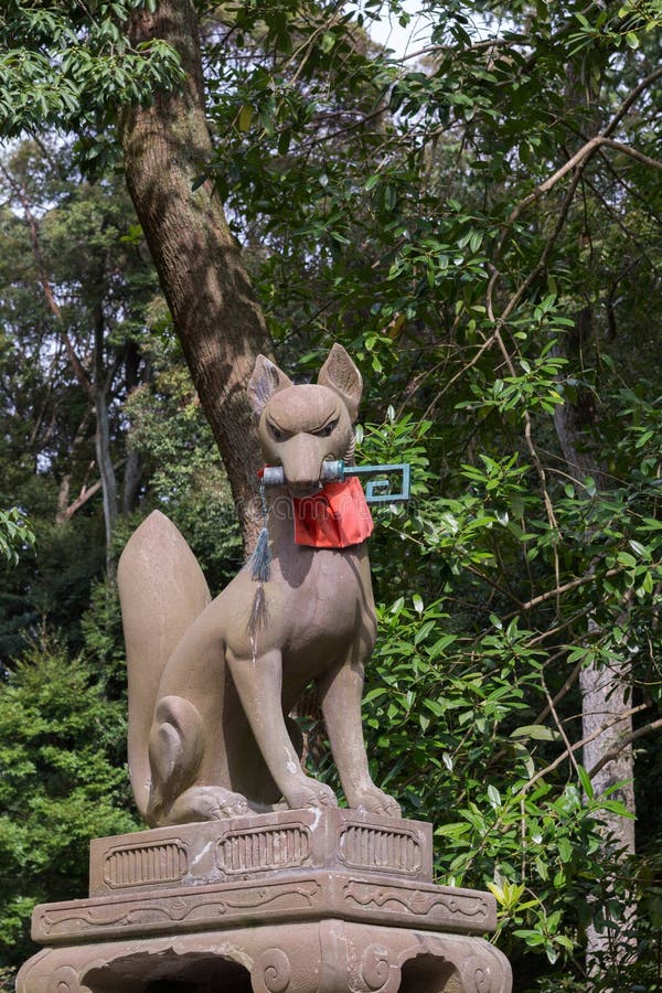 Kitsune, la volpe, tiene un digitare la sua bocca a Fushimi Inari Tais immagini stock libere da diritti Kitsune, la volpe, tiene un digitare la sua bocca a Fushimi Inari Tais immagini stock libere da diritti