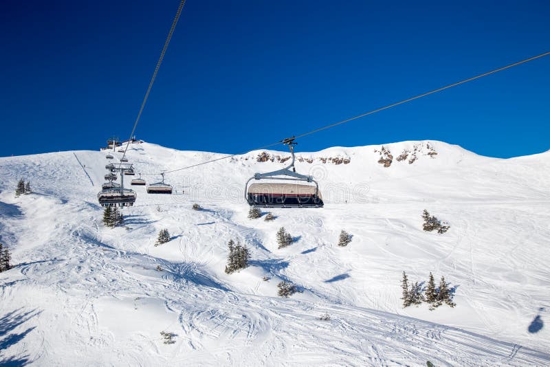 KITZBUEHEL, AUSTRIA, February 18, 2016 - Skiers on ski lift enjoying the view to foggy Alps in Austria and beautiful snowy country royalty free stock photos KITZBUEHEL, AUSTRIA, February 18, 2016 - Skiers on ski lift enjoying the view to foggy Alps in Austria and beautiful snowy country royalty free stock photos