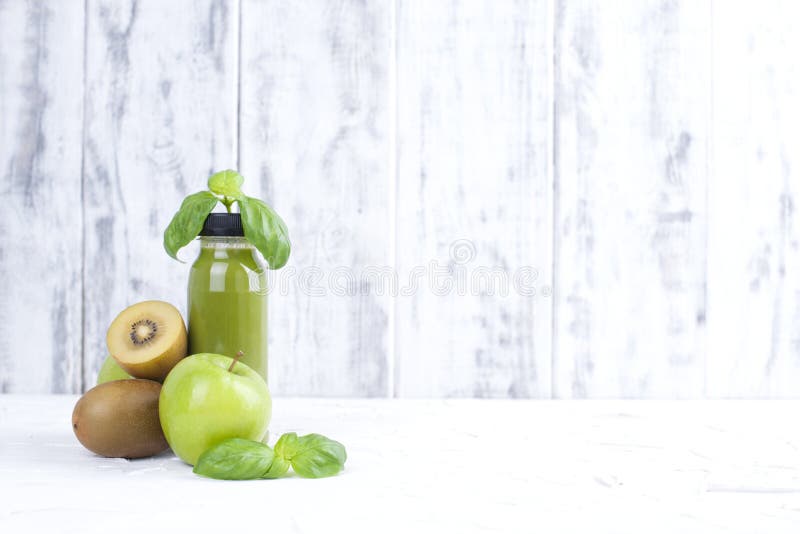 Kiwi, green apple, basil and. juice in a plastic bottle. Detox food. White wooden background. Copy space stock images Kiwi, green apple, basil and. juice in a plastic bottle. Detox food. White wooden background. Copy space stock images