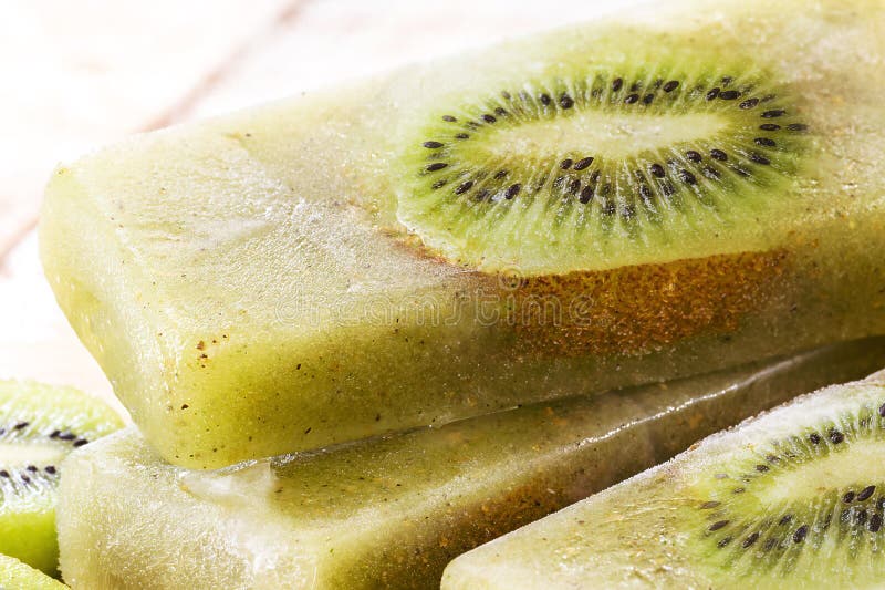 kiwi popsicle on wooden table, homemade and cold dessert, made with fresh fruits without sugar.