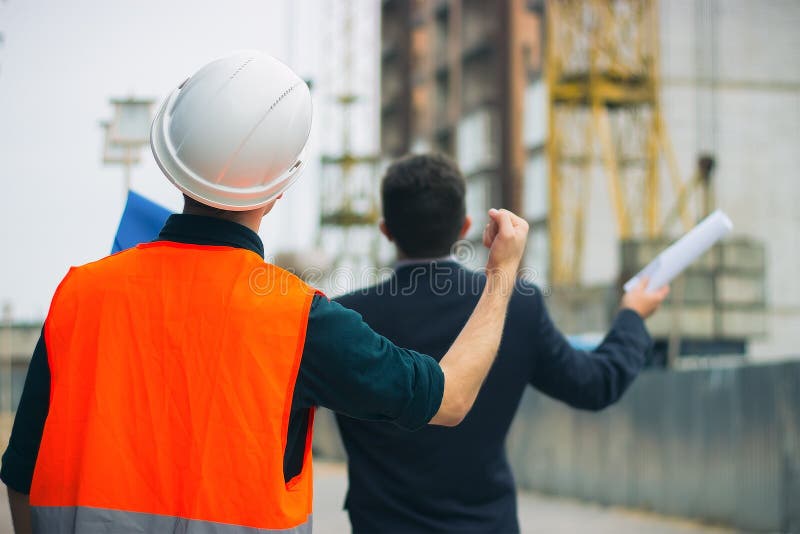 Klant in spanning en de arbeider van de aannemersvoorman met helm en vest bij de woningbouw die vuist op het verkeerde werk tonen royalty-vrije stock afbeeldingen Klant in spanning en de arbeider van de aannemersvoorman met helm en vest bij de woningbouw die vuist op het verkeerde werk tonen royalty-vrije stock afbeeldingen