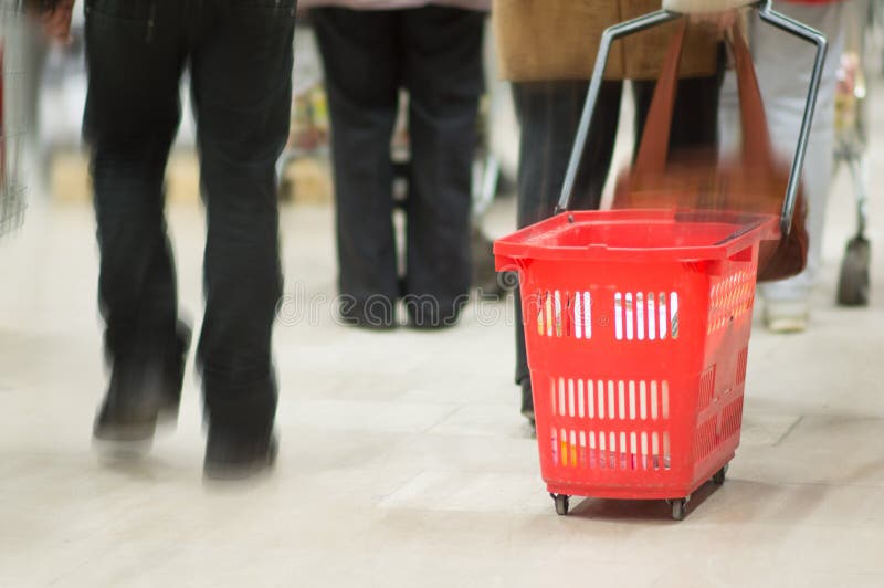 Klanten met rode manden in supermarkt stock fotografie Klanten met rode manden in supermarkt stock fotografie