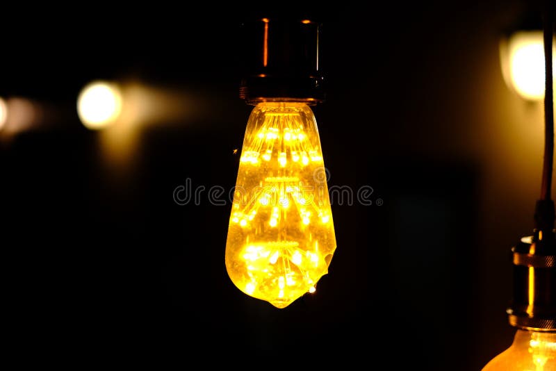 Klassische Retro- weißglühende geführte elektrische Lampe auf schwarzem Hintergrund stockfoto