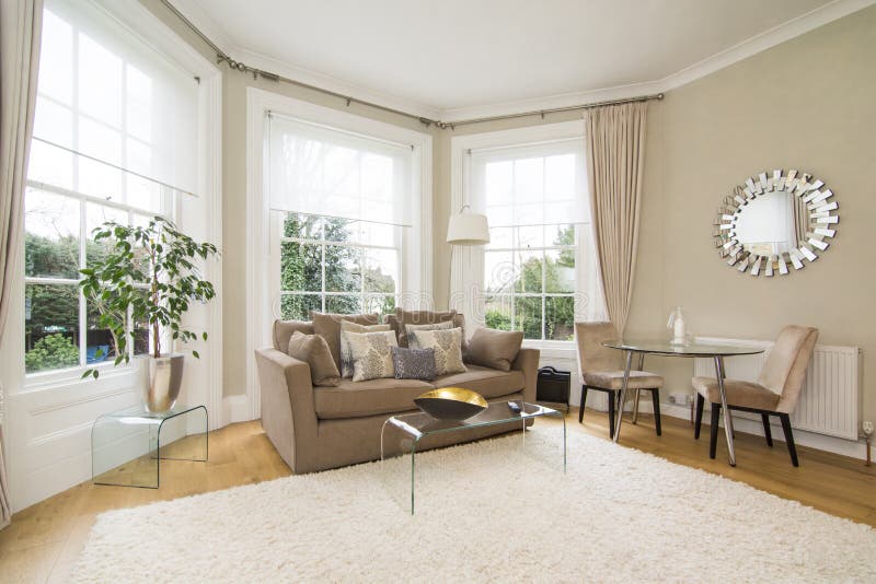 Klassisches Wohnzimmer mit dem großen Erkerfenster, das reizenden Garten gegenüberstellt stockfotografie Klassisches Wohnzimmer mit dem großen Erkerfenster, das reizenden Garten gegenüberstellt stockfotografie