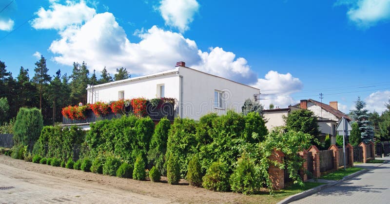 Klassiskt hus med blommaträdgården royaltyfri foto Klassiskt hus med blommaträdgården royaltyfri foto