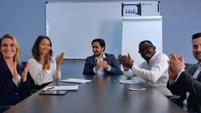Klatschende Hände des erfüllten stolzen Geschäftsteams und Betrachten der Kamera in einem modernen Büro stockfoto Klatschende Hände des erfüllten stolzen Geschäftsteams und Betrachten der Kamera in einem modernen Büro stockfoto