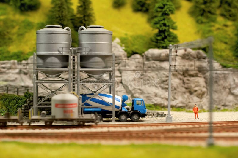 Miniature model cement truck loading from track-side silos. Miniature model cement truck loading from track-side silos