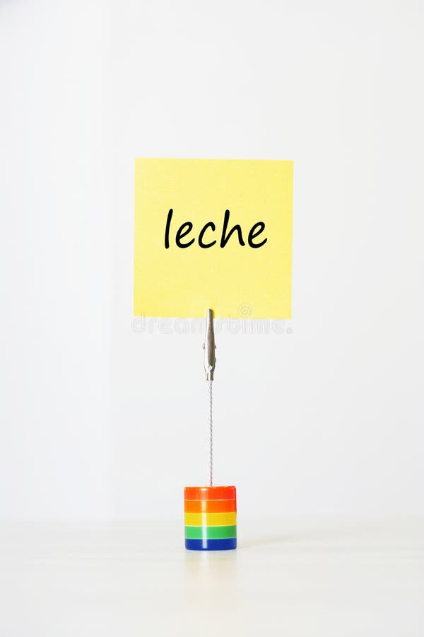 Sticky notepaper with Spanish text leche (Milk) clipped to a multicolored card holder. Sticky notepaper with Spanish text leche (Milk) clipped to a multicolored card holder