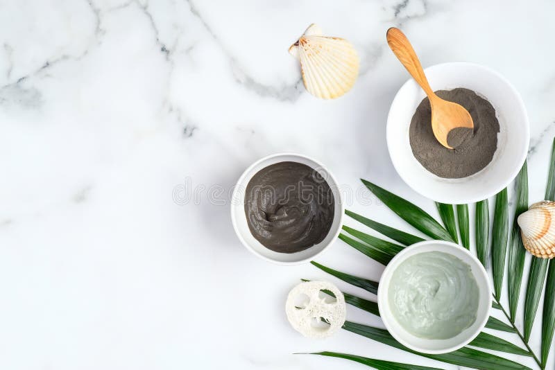 Clay facial mask in bowls on marble background. Homemade skin care cosmetic mask for face, natural organic SPA cosmetic products. Flat lay, top view. Clay facial mask in bowls on marble background. Homemade skin care cosmetic mask for face, natural organic SPA cosmetic products. Flat lay, top view