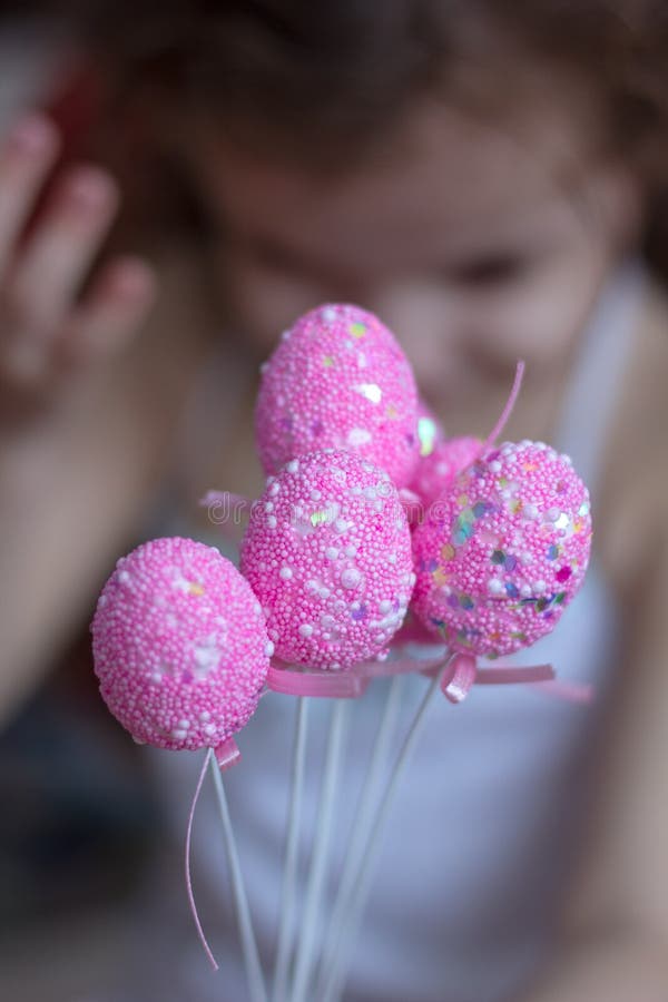 Klein meisje houdt roze eitjes in handen. royalty-vrije stock afbeeldingen