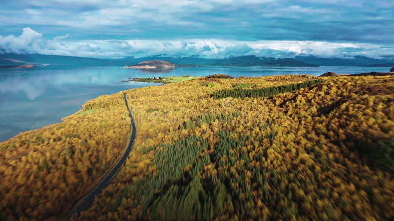 Kleine Dörfer und landwirtschaftliche Felder an den bewaldeten Ufern des Fjords.