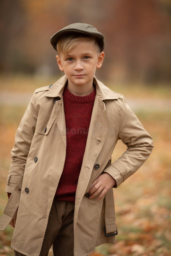 Kleine jongen die in een jas staat stock fotografie Kleine jongen die in een jas staat stock fotografie