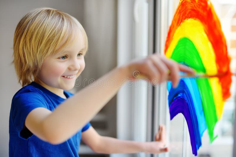 Kleine jongen die op de vensterregenboog loopt terwijl coronavirus quarantaine Rainbow-teken is een symbool van hoop, betekent da stock afbeelding Kleine jongen die op de vensterregenboog loopt terwijl coronavirus quarantaine Rainbow-teken is een symbool van hoop, betekent da stock afbeelding