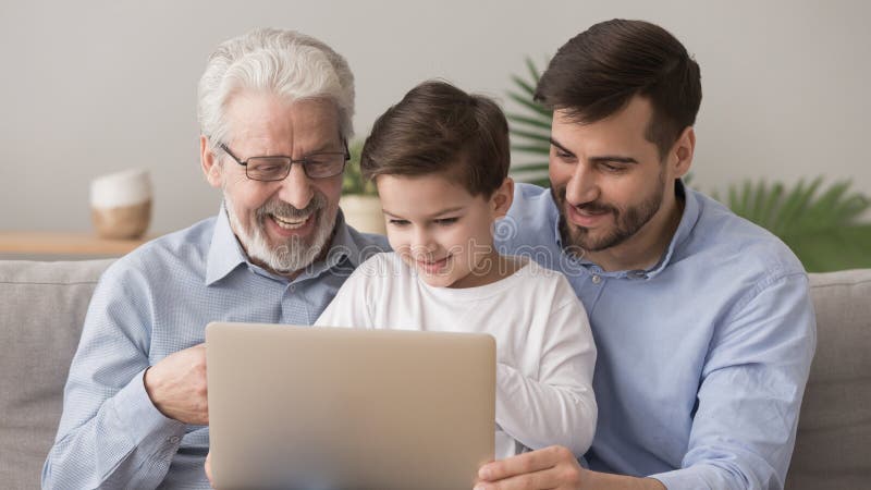 Kleine jongen kletsen met vader en gelukkige grootvader die een laptop gebruikt