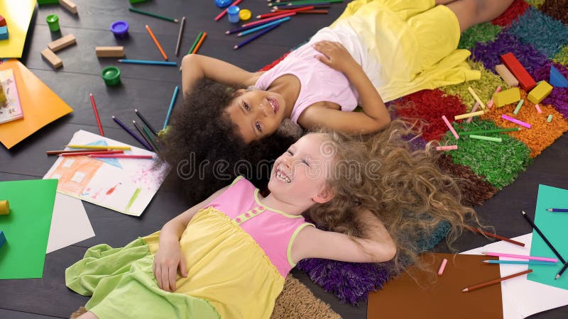 Kleine leuke multiraciale op tapijt liggen en vrienden die, gelukkige kinderjaren lachen royalty-vrije stock afbeeldingen Kleine leuke multiraciale op tapijt liggen en vrienden die, gelukkige kinderjaren lachen royalty-vrije stock afbeeldingen