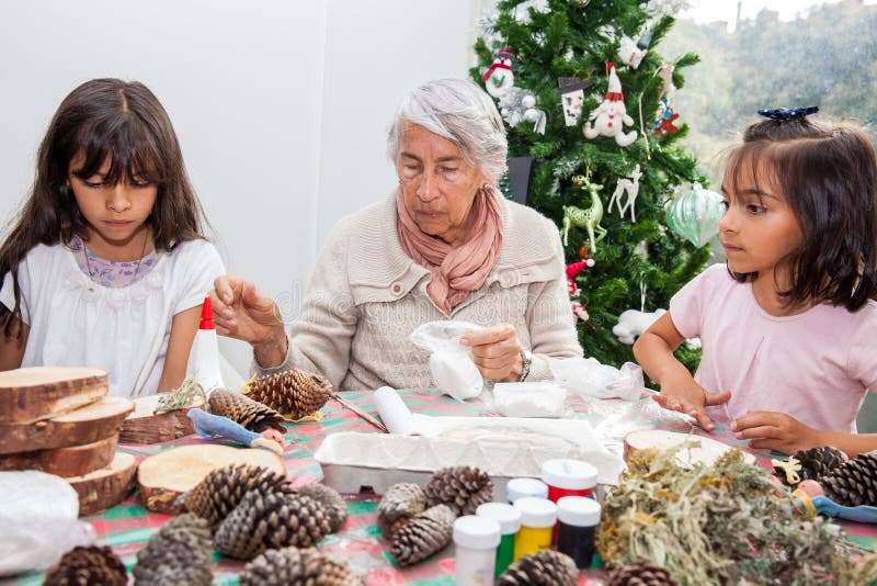 Kleine meisjes die plezier hebben terwijl ze kerstmis maken Nativity maken met hun grootmoeder royalty-vrije stock foto's Kleine meisjes die plezier hebben terwijl ze kerstmis maken Nativity maken met hun grootmoeder royalty-vrije stock foto's