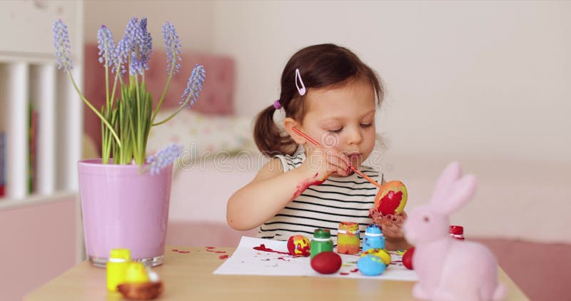 Kleine Mädchen bemalen Ostereier zu Hause stock video footage