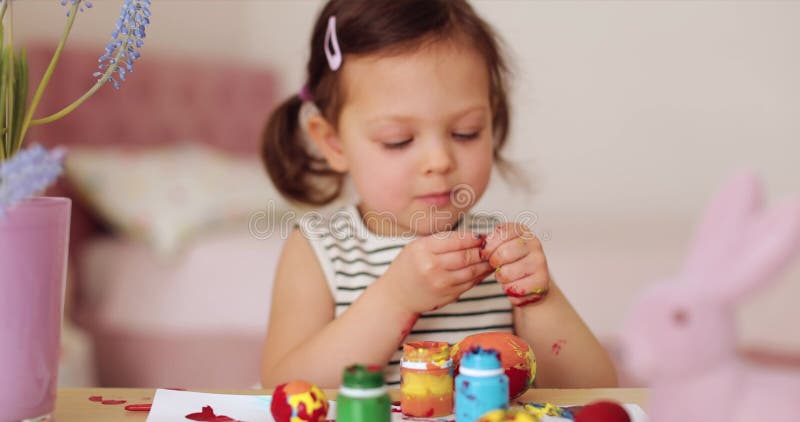 Kleine Mädchen bemalen Ostereier zu Hause stock footage