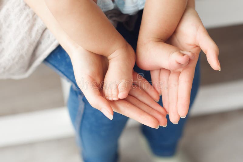 Kleine neugeborene Babybeine auf weiblichen Händen, Nahaufnahme stockfotografie Kleine neugeborene Babybeine auf weiblichen Händen, Nahaufnahme stockfotografie