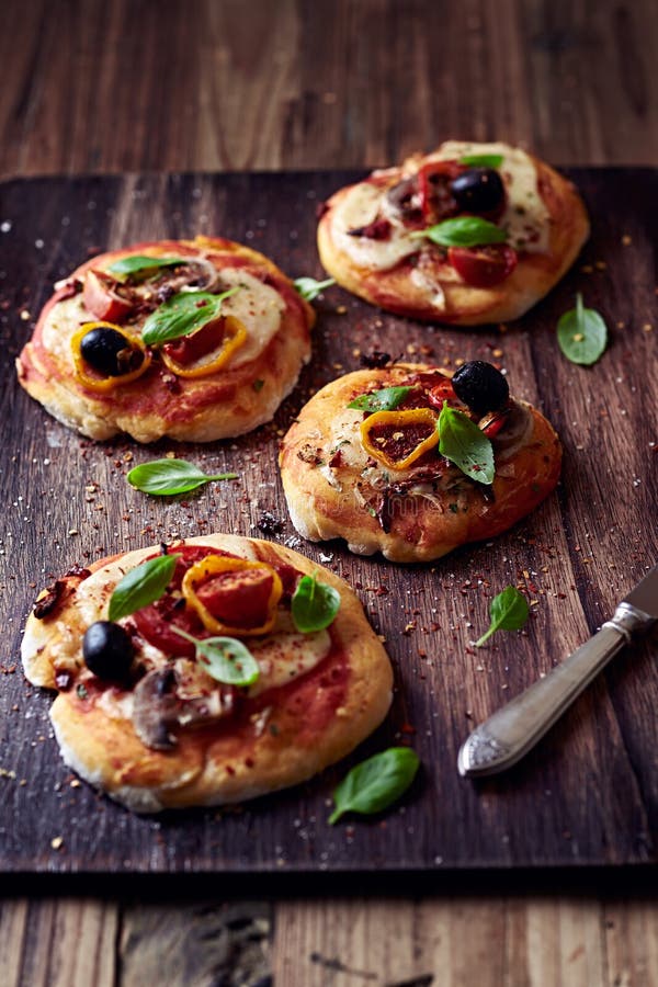 Kleine Pizzas Mit Mozzarella, Salami Und Pilzen Stockfoto - Bild von ...