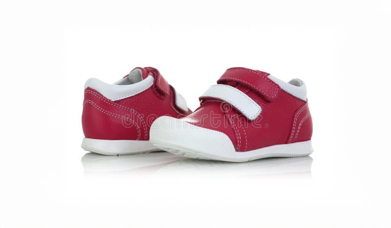 Kleine rote Schuhe isoliert auf weißem Hintergrund. Kinderschuhe isoliert auf weißem Hintergrund