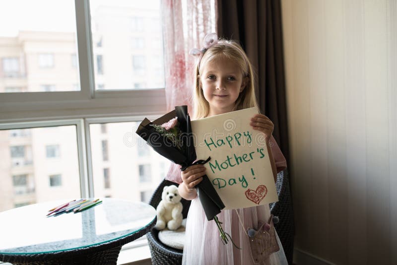 Kleine Tochter, die gemalte Postkarte und Blumenstrauß von Blumen für Mutter hält Gl?ckliches Muttertageskonzept lizenzfreies stockbild Kleine Tochter, die gemalte Postkarte und Blumenstrauß von Blumen für Mutter hält Gl?ckliches Muttertageskonzept lizenzfreies stockbild
