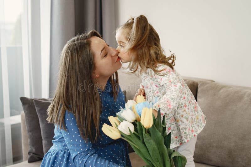 Kleine Tochter gibt mutter blumen tulpen. Kleines Mädchen mit Blumen. Mutter ist schwanger. Grüße für Mutter.
