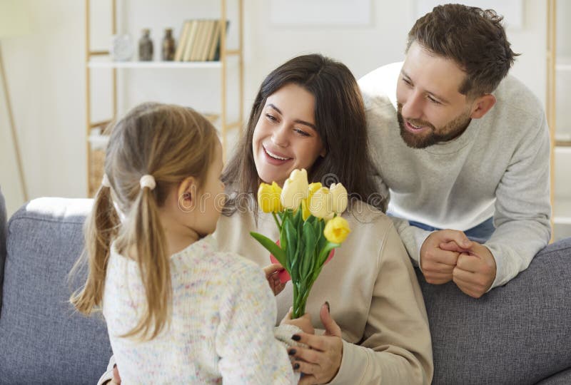 Kleine Tochter Mädchen und liebende junge Mutter Vater gratulieren stockfotos