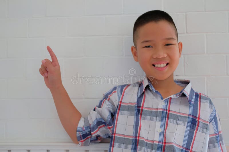kleiner asiatischer lächelnder u. zeigender Kinderjungenkinderkinderschüler lizenzfreie stockfotografie kleiner asiatischer lächelnder u. zeigender Kinderjungenkinderkinderschüler lizenzfreie stockfotografie