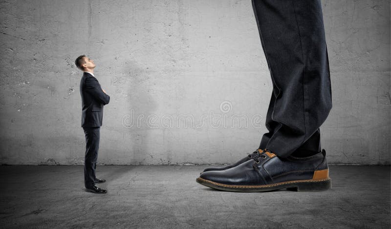 Kleiner Geschäftsmann, der oben auf enormen Beinen eines anderen Mannes schaut