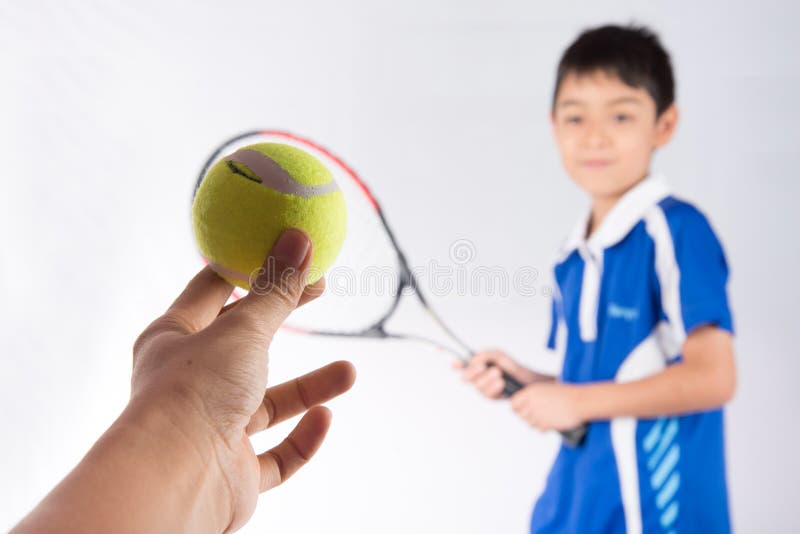 Kleiner Junge, der in der Hand Tennisschläger und -Tennisball spielt lizenzfreies stockbild Kleiner Junge, der in der Hand Tennisschläger und -Tennisball spielt lizenzfreies stockbild