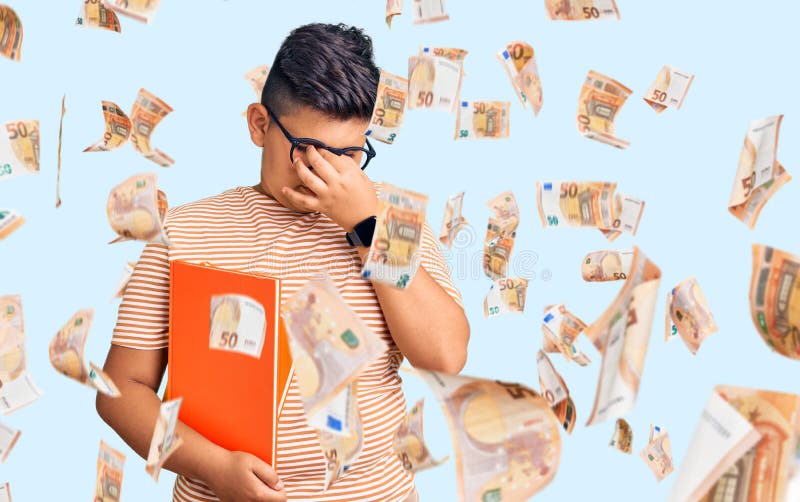 Kleiner Junge, der ein Buch mit einer Brille trägt, müde Reibung der Nase und der Augen, Müdigkeit und Kopfschmerzen stockbild