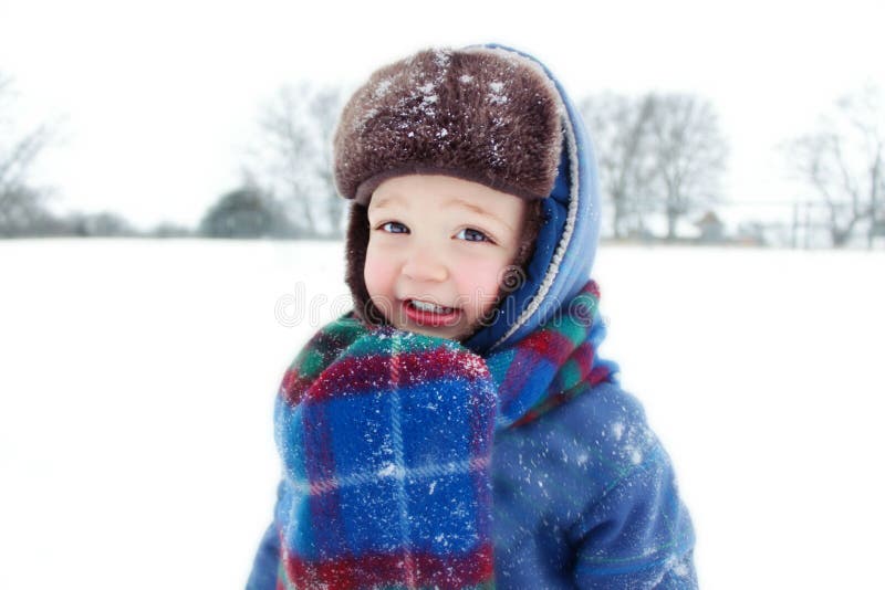 Kleiner Junge, der im Schnee spielt