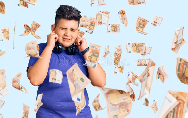 Kleiner Junge, der Musik mit Kopfhörern hört, die Ohren mit Fingern bedecken, mit irritiertem Ausdruck für das Geräusch der lauten lizenzfreie stockfotos