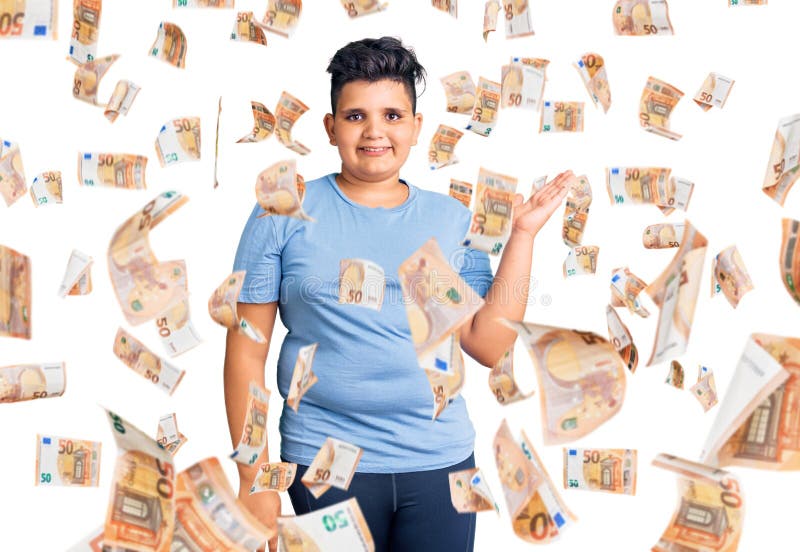 Kleiner Junge, der Sportkleidung trägt und fröhlich präsentiert und mit Handfläche zeigt, wie er die Kamera anschaut lizenzfreies stockfoto