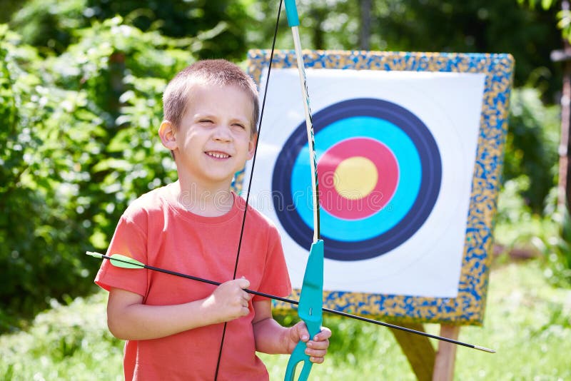 Kleiner Junge mit großem Bogen nahe Sportziel stockfotografie Kleiner Junge mit großem Bogen nahe Sportziel stockfotografie