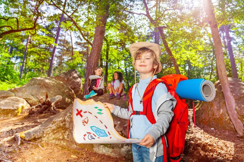 Kleiner Junge mit Schatzkarte im Waldspiel stockbild