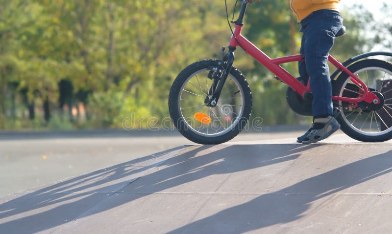 Kleiner Junge strebt herein Sport auf einem Fahrrad an und lernt, in einen Rochenpark zu reiten, der die Steigung in der Sonne be lizenzfreies stockfoto Kleiner Junge strebt herein Sport auf einem Fahrrad an und lernt, in einen Rochenpark zu reiten, der die Steigung in der Sonne be lizenzfreies stockfoto