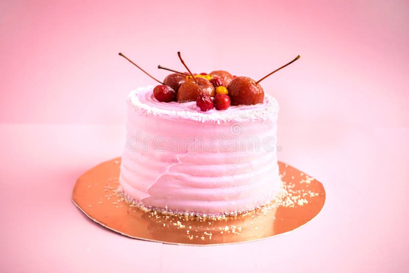 Kleiner runder rosa Geburtstagskuchen mit Mastix und Dekor trägt Früchte stockfoto