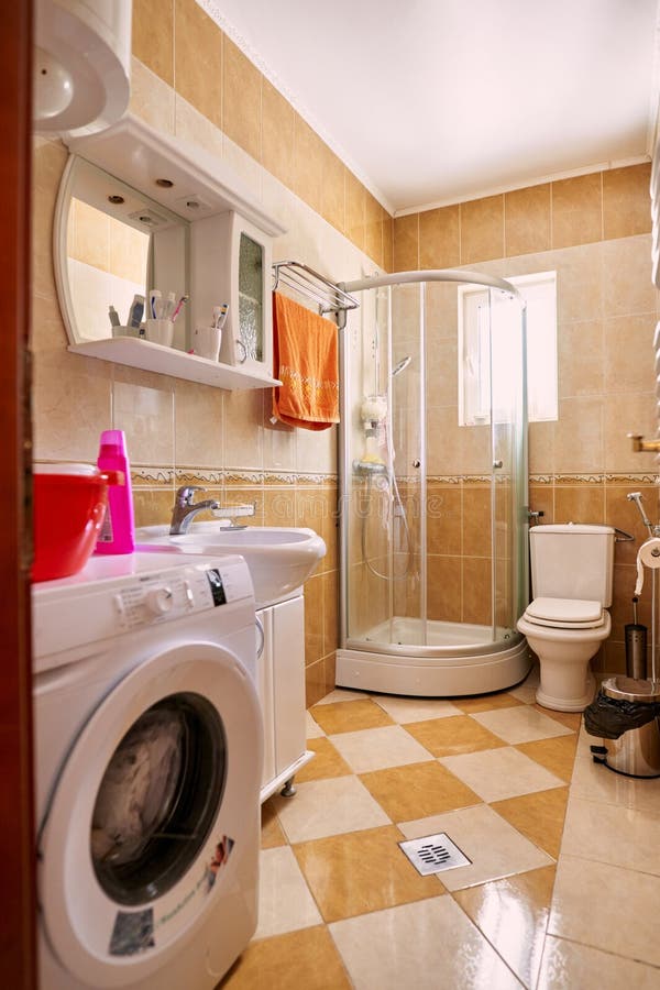 Kleines Badezimmer mit Dusche WC Waschbecken Waschmaschine und Boiler stockfoto