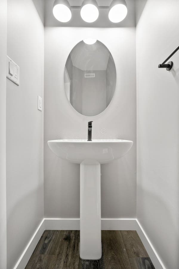 Kleines Badezimmer mit weißem Waschbecken und Spiegel lizenzfreies stockfoto
