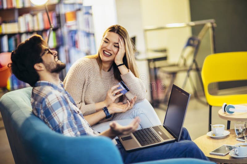 Kleines Ehepaar mit Laptop im Café mit Kreditkarte stockbilder